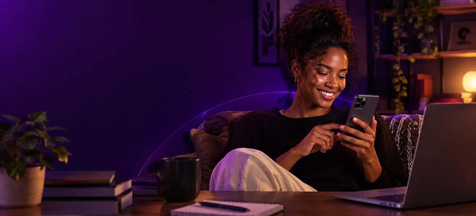 Mulher sorrindo enquanto usa o celular em casa
